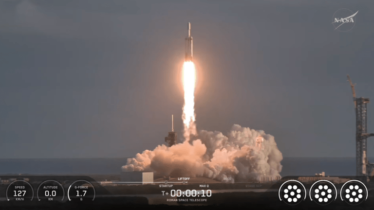 a white telescope launches aboard a rocket