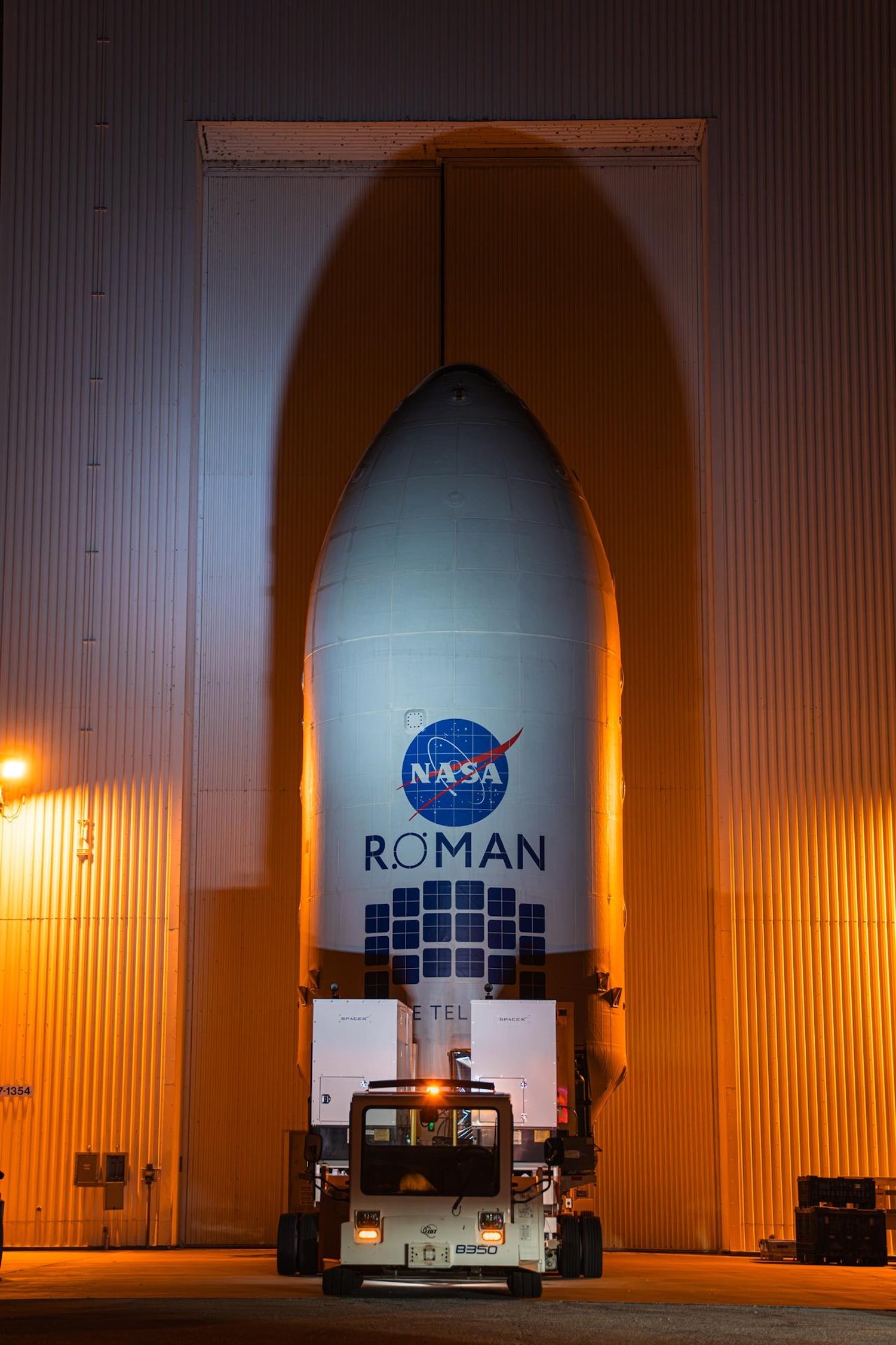Teams inside the Payload Hazardous Servicing Facility at NASA’s Kennedy Space Center in Florida encapsulate the agency’s Nancy Grace Roman Space Telescope within the payload fairing on Friday, August 21, 2026, ahead of mating to a SpaceX Falcon Heavy rocket. Encapsulation shields the spacecraft during rollout, ascent, and the early phases of flight. Image: Kennedy Space Center / NASA