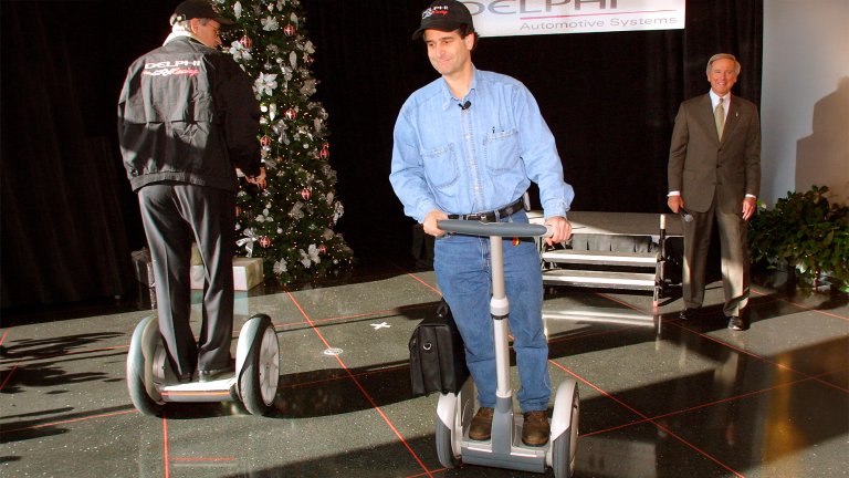 Segway HT inventor, founder, Chairman and CEO Dean Kamen (center) demonstrates his New Personal Transporter on December 18, 2001 to Delphi Automotive Systems’ President, Chairman, and CEO J.T. Battenberg (right) at Delphi’s headquarters in Troy, Michigan. On the left is J. Douglas Field, Segway Company’s Chief Engineer. Battenberg said the Segway HT is going to simplify personal travel in places that are impractical for automobiles.