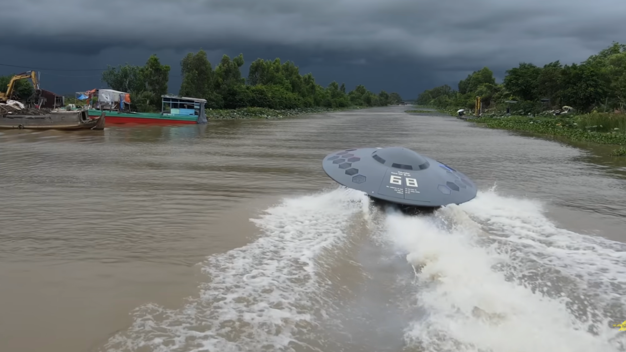 a boat shaped like a flying saucer speeding down a river