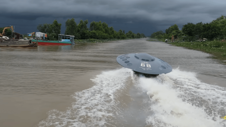a boat shaped like a flying saucer speeding down a river