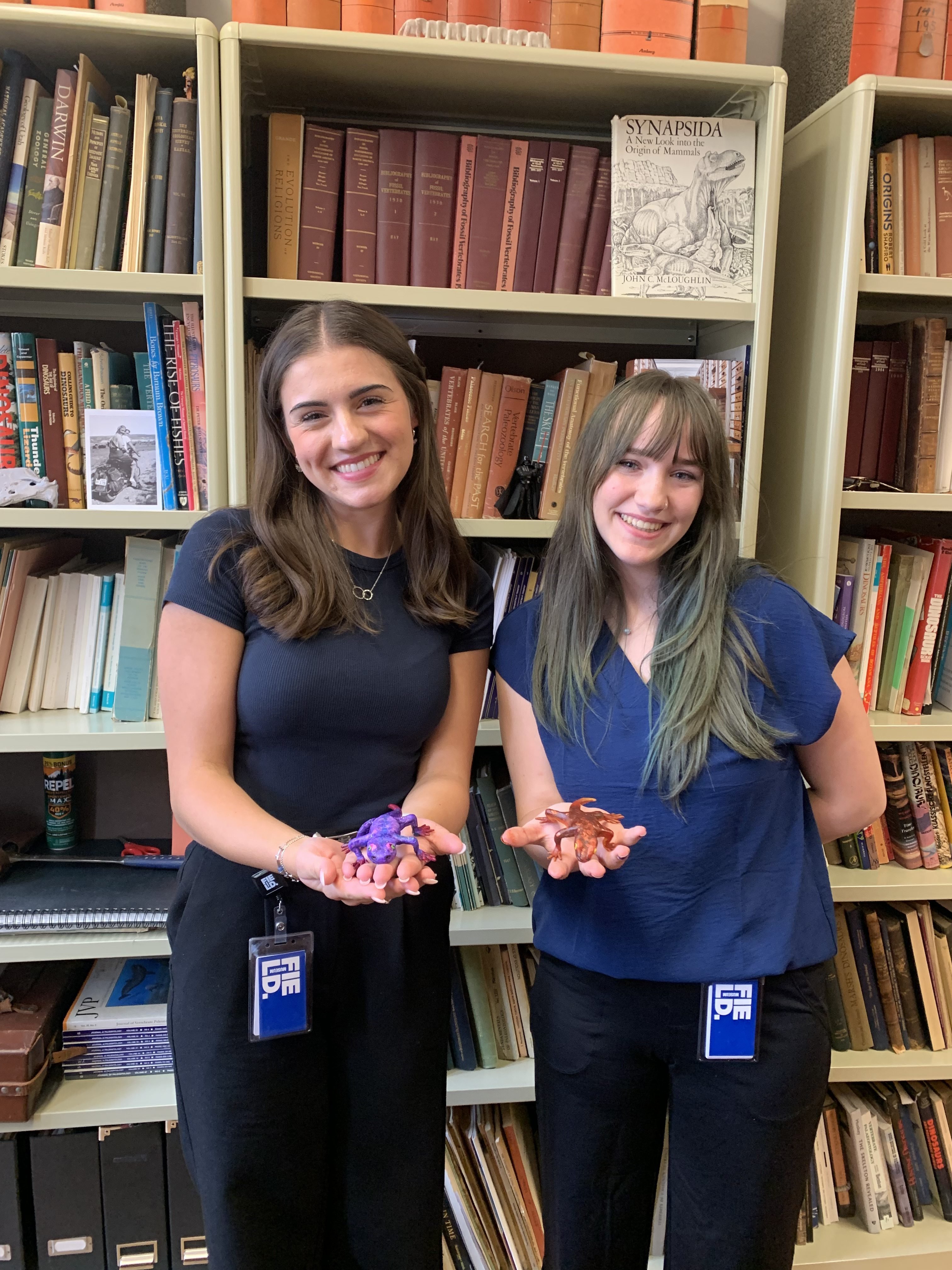 two women holding a model of a salamander