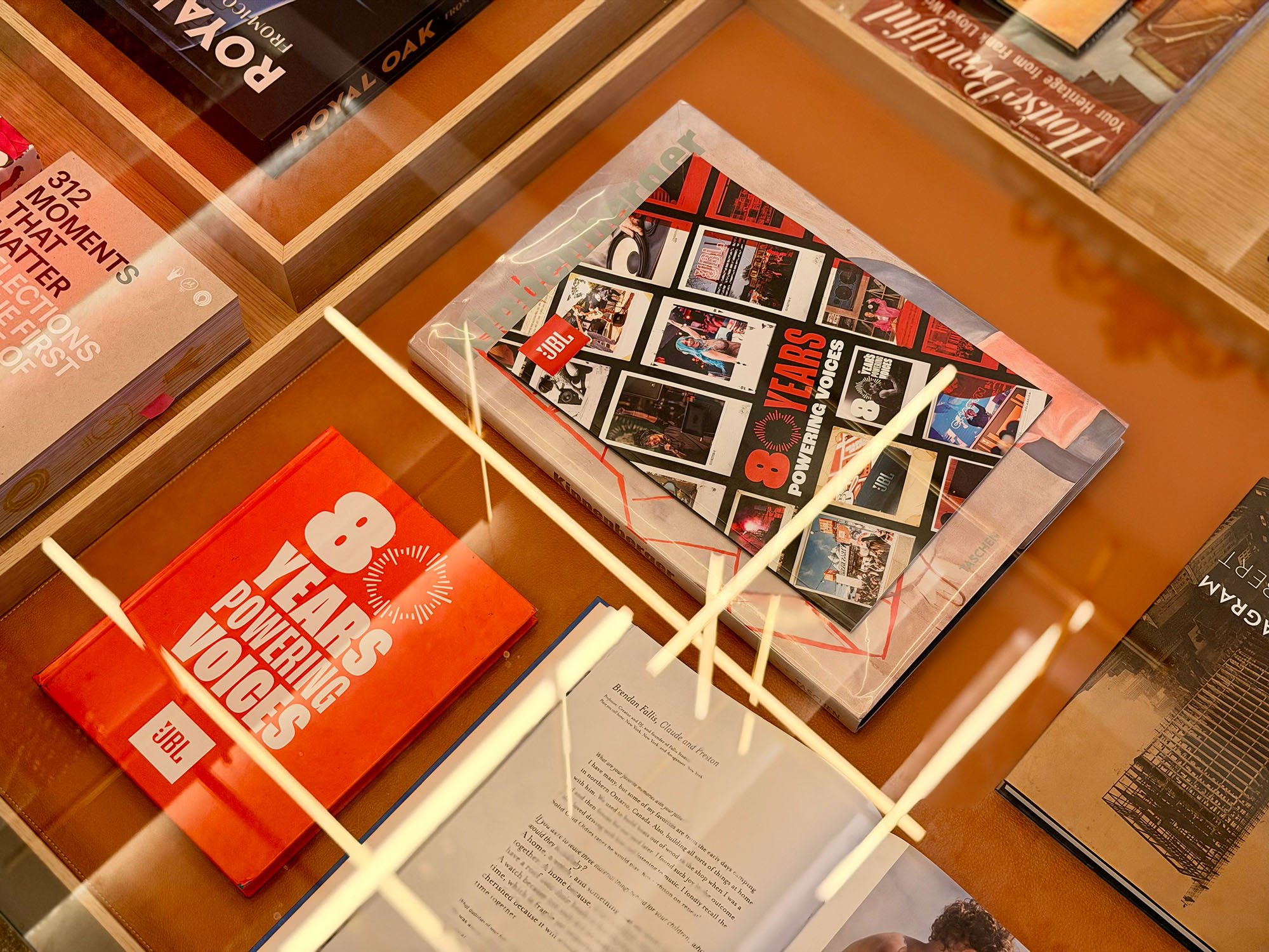 JBL 80 Year anniversary books shown under a glass table