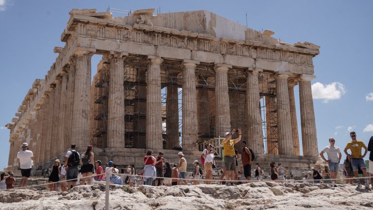 Tourists visit the Temple of Parthenon at the Acropolis of Athens, Greece, on June 19, 2026. The restoration of the western pediment of the Parthenon and removal of the external scaffolding from the western façade of the temple, has been finished after 220 years. (Photo by Nick Paleologos / SOOC via AFP)