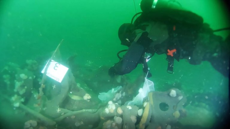 Diver examining underwater UC-30 sub wreck