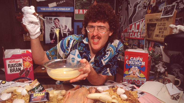 a man with a mustache and curly hair poses with a lot of breakfast cereal
