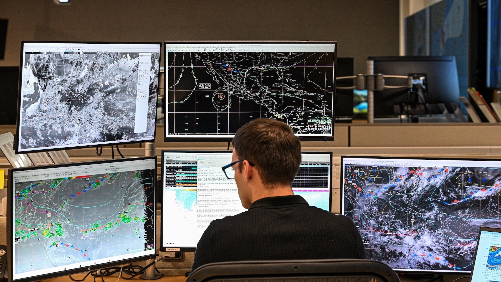 Tropical analysis meteorologist Aidan Mahoney works at his station at the National Oceanic and Atmospheric Administration's (NOAA) National Hurricane Center in Miami, Florida, on May 30, 2025. The administration of US President Donald Trump has fired hundreds of staff at the National Oceanic and Atmospheric Administration (NOAA) and deleted government websites with data on the weather and climate. (Photo by CHANDAN KHANNA / AFP)