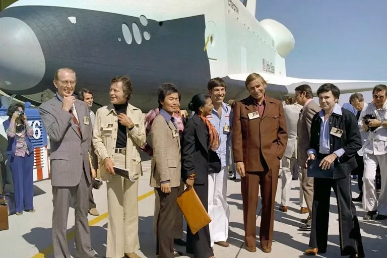 people standing in front of shuttle