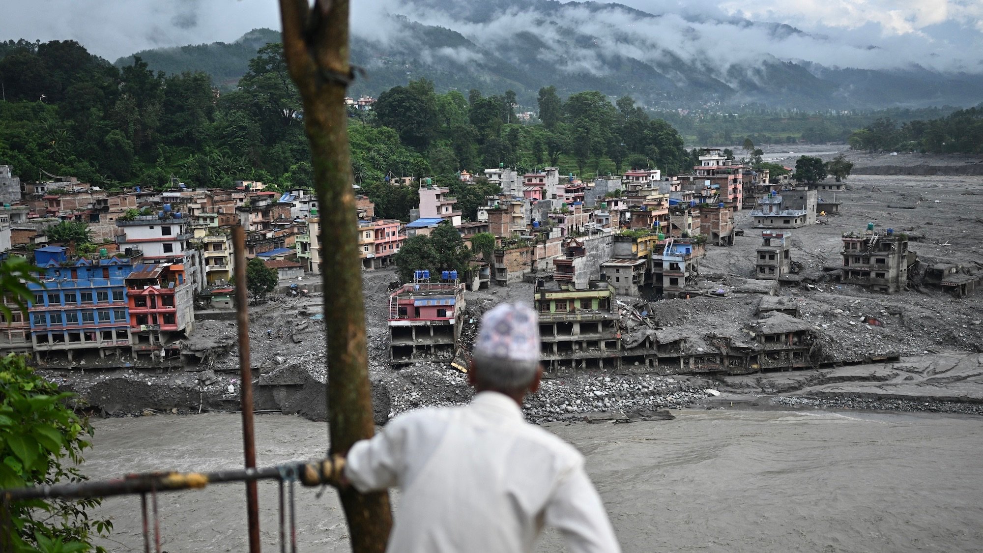 A man looks at the remains in the aftermath of flash floods at Trishuli in Nepal's Nuwakot district on September 7, 2026. The August 26 glacial and mountain collapse on the China-Nepal border killed at least 1,398 people, with more than 5,500 missing, including around 800 foreigners. (Photo by Pedro PARDO / AFP)
