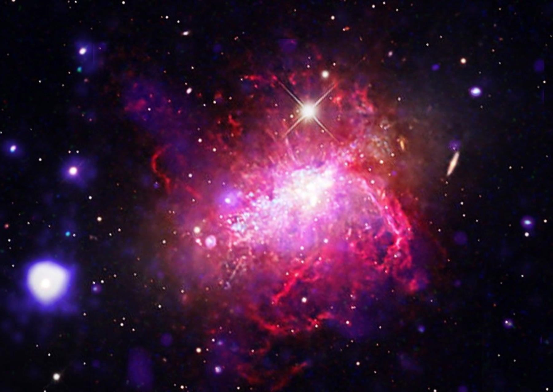 A compact dwarf irregular galaxy undergoing a violent, compact burst of star formation. Chandra and XMM-Newton observations (blue and purple) reveal massive bubbles of million-degree gas inflated by stellar winds, set against a backdrop of optical light (magenta, orange and white) imaged by Adam Block. Dwarf starburst galaxies can serve as local laboratories for studying the conditions of the early universe, where small, primitive galaxies formed stars at frantic rates. Image: X-ray: (XMM):ESA/XMM-Newton, (Chandra): NASA/CXC/SAO; Optical: Univ.of Arizona/Mt Lemmon SkyCenter/Adam Block/Josep Drudis; Image Processing: NASA?CXC/SAO/L. Frattare.