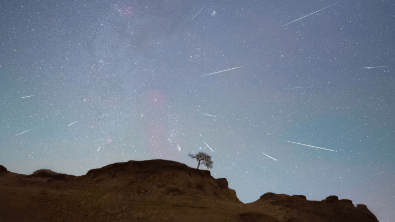 a meteor shower over mountains