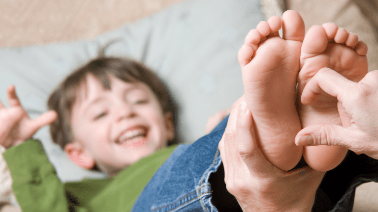 a little boy's feet are tickled