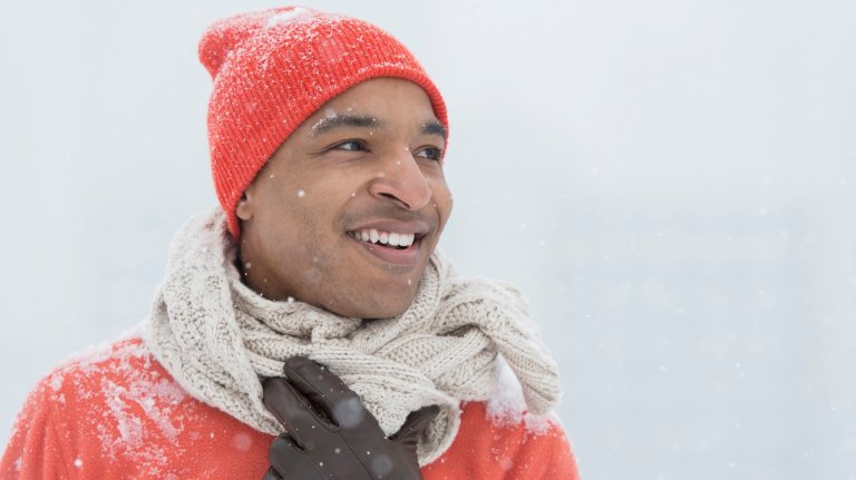 man wearing gloves and scarf in snow