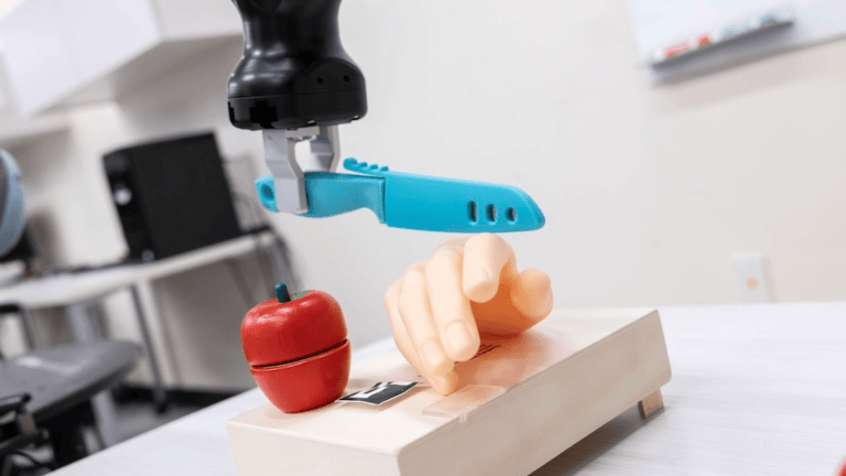 a robot with a fake knife, hand, and apple
