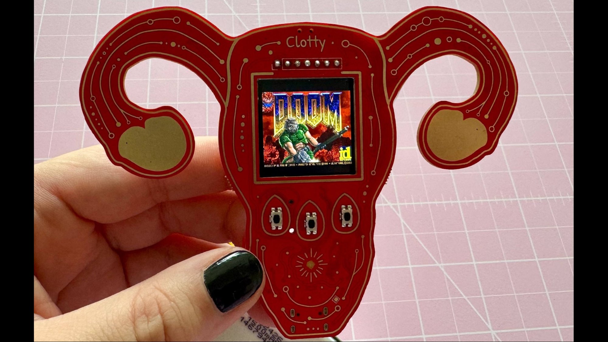 Uterus shaped mini computer showing Doom game load screen on display
