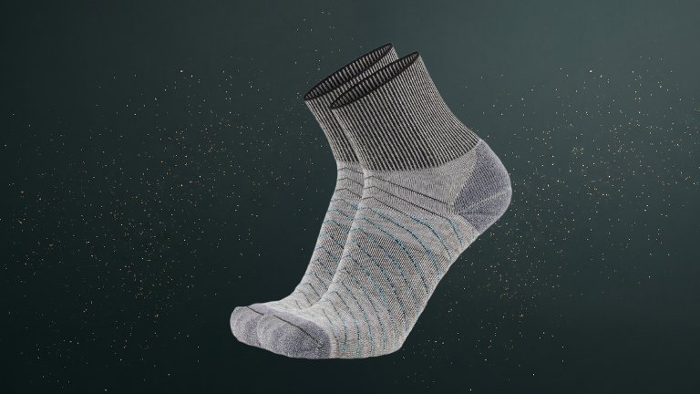 Grey Gordini Signal Socks against a green speckled practical gift guide background
