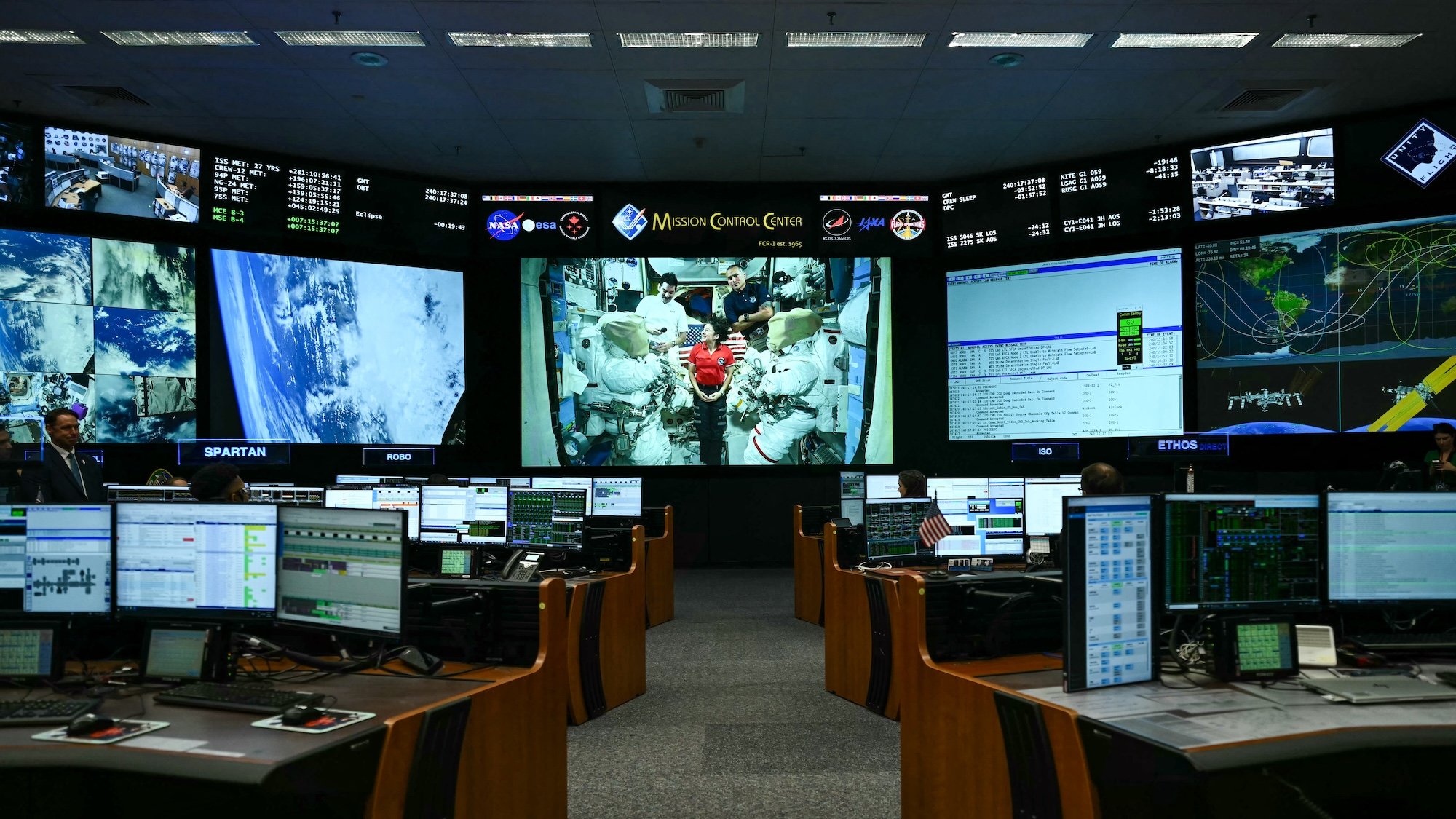 Crew members of the International Space Station (ISS) are seen on a screen at the Mission Control Center as US President Donald Trump visits NASA Lyndon B. Johnson Space Center in Houston, Texas, on August 28, 2026. During his visit, President Trump honored the Artemis II crew with the Congressional Space Medal of Honor for their historic mission around the Moon and signed an executive order that aims to create a US Space Academy. (Photo by Kent NISHIMURA / AFP)