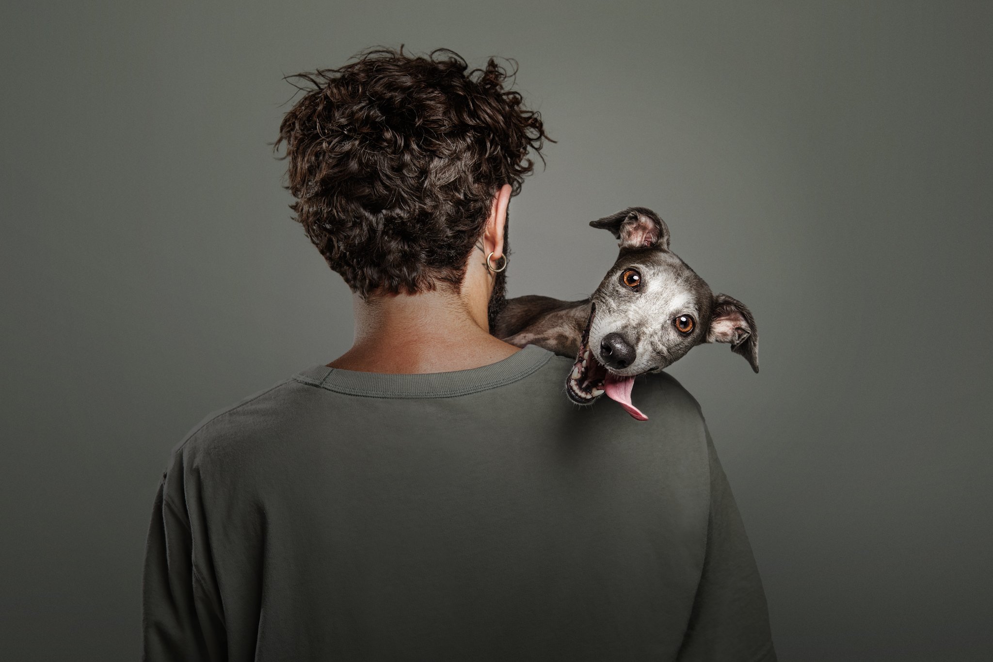 panting dog on man's shoulder