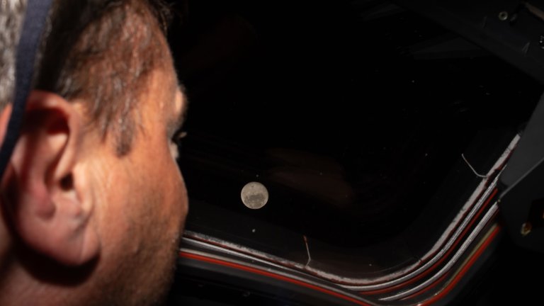 Astronaut Reid Wiseman looks out Orion space capsule at the moon during Artemis II Mmission