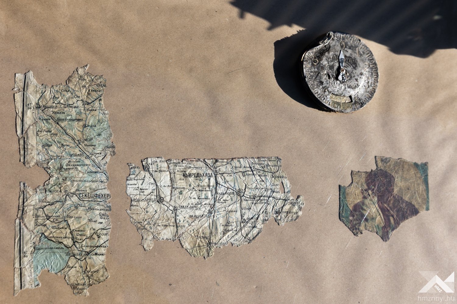 Items recovered from Soviet plane crashing including pieces of a map, an illustration that appears to show a cat, and a compass