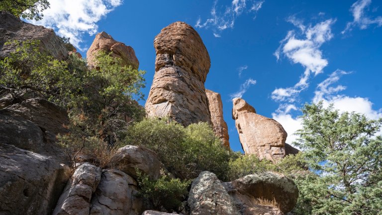 A stunning view of Chiricahua National Monument showcasing its unique rock formations and dramatic landscapes. The rugged terrain and natural beauty highlight the park's geological wonders and serene environment.